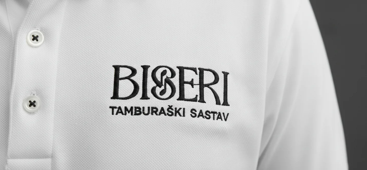 Logotip Biseri izvezen na bijeloj polo majici, s natpisom Tamburaški sastav ispod naziva